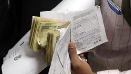 The woman, Nirmala Devi, was standing towards the tail end of the queue when a man snatched the cloth bag she was carrying and fled, said police.