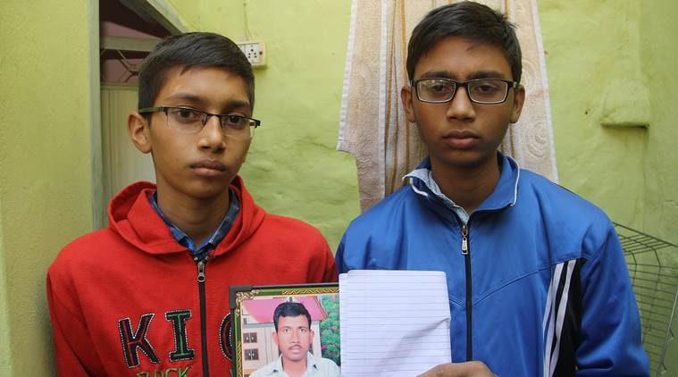 BSF Jawans sons Hitesh and Paras( red) holding their father's pic at home in Rohtak on Monday .November 21, 2016: Express Photo