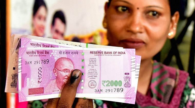 A lady display the currency notes and indelible ink after withdrawing the amount at the State Bank in Bengaluru on Wednesday. (PTI Photo by Shailendra Bhojak)