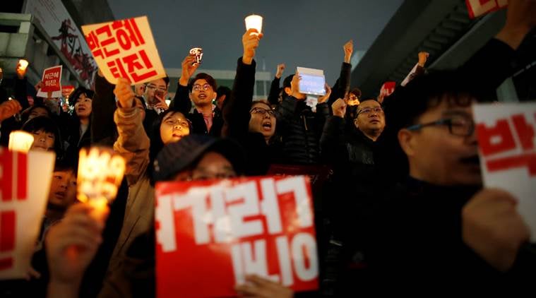 South Korean people chant slogans during a rally calling on embattled President Park Geun-hye to resign over a growing influence-peddling scandal in central Seoul, South Korea, November 5, 2016. The placards read, "Step down Park Geun-hye". REUTERS/Kim Hong-Ji