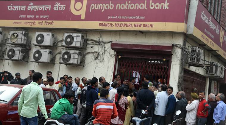 People queue up outside a bank in Mayapuri Bank. Express photo by Renuka Puri