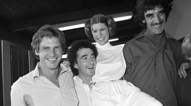 FILE - In this Oct. 5, 1978 photo, from left, actors Harrison Ford, Anthony Daniels, Carrie Fisher and Peter Mayhew take a break from filming a television special in Los Angeles to be telecast during the holidays. On Tuesday, Dec. 27, 2016, a publicist says Fisher has died at the age of 60. (AP Photo/George Brich, File)