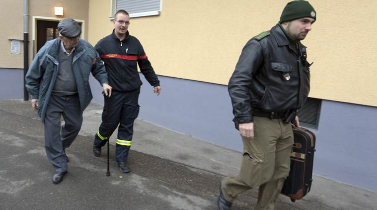 Police help a man to leave his apartment in Augsburg, Germany, Sunday Dec. 25, 2016. Thousands of people in the German town of Augsburg have temporarily left Christmas presents and decorations behind while authorities disarm a World War II bomb. The bomb was uncovered last week during construction work. (Stefan Puchner/dpa via AP)