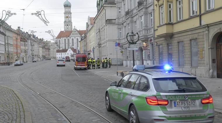 A police vehicle driving through an almost empty street in Augsburg, Germany, Sunday Dec. 25, 2016. Thousands of people in the German town of Augsburg have temporarily left Christmas presents and decorations behind while authorities disarm a World War II bomb. The bomb was uncovered last week during construction work. (Stefan Puchner/dpa via AP)