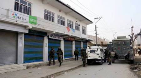 Pulwama: Army personnel cordon off the area outside Jammu and Kashmir Bank which was looted by suspected militants, at Ratnipora in Pulwama on Thursday. PTI Photo  (PTI12_15_2016_000318B)
