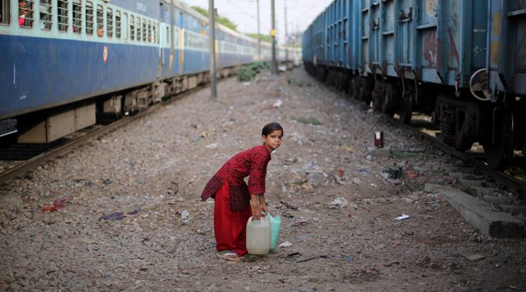 Afsana holds on to her water cans as she waits for the trains to pass near her house in Harkesh Nagar. She collected the water from a nearby Delhi Jal Board station and has to cross the tracks to reach home. Express photo by Oinam Anand. 16 June 2016 *** Local Caption *** Afsana holds on to her water cans as she waits for the trains to pass near her house in Harkesh Nagar. She collected the water from a nearby Delhi Jal Board station and has to cross the tracks to reach home. Express photo by Oinam Anand. 16 June 2016