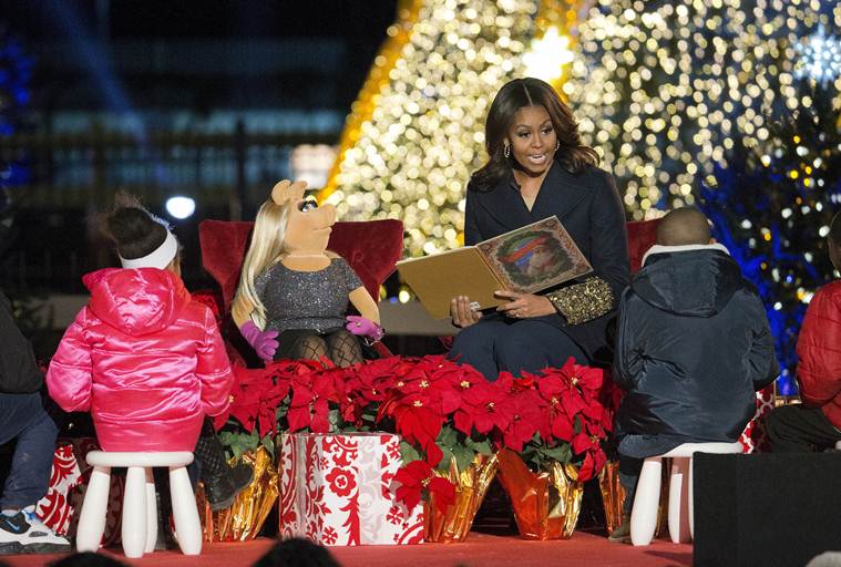 FILE - In this Dec. 3, 2015, file photo, first lady Michelle Obama with Miss Piggy, left, read 'Twas the Night Before Christmas for children on stage during the National Christmas Tree Lighting ceremony at the Ellipse in Washington. When Michelle Obama considered the daunting prospect of becoming first lady, she purposely avoided turning to books by her predecessors for guidance. Instead, she turned inward. (AP Photo/Pablo Martinez Monsivais)
