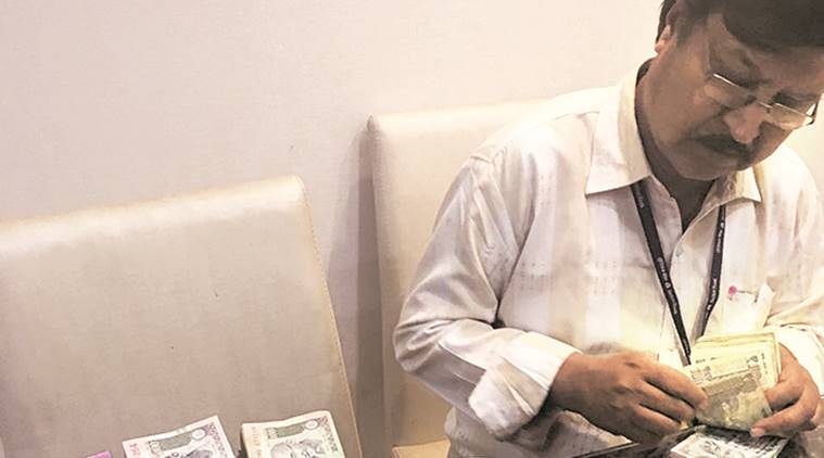 A bank official counting notes seized by the DGCEI after raids on a prominent Pune firm. Express