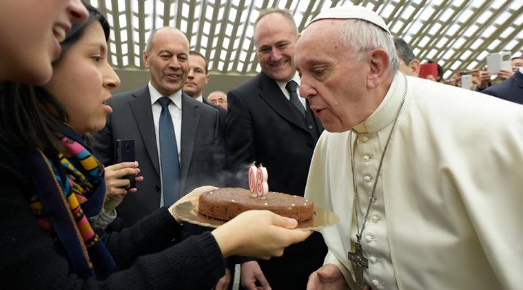 Pope Francis blows a candle on a cake given to him by faithful during his weekly general audience in Paul VI Hall, at the Vatican, Wednesday, Dec. 14, 2016. Pope Francis is marking his 80th birthday on Saturday with a morning Mass with his cardinals and an otherwise "normal" day of back-to-back meetings and audiences. (L'Osservatore Romano/Pool Photo via AP)
