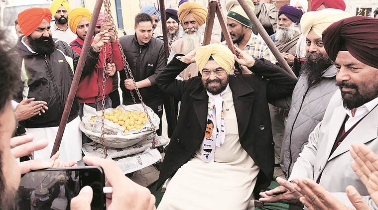 Residents of Badanpur village in Kharar constituency weigh AAP candidate Kanwar Sandhu against laddoos. Express