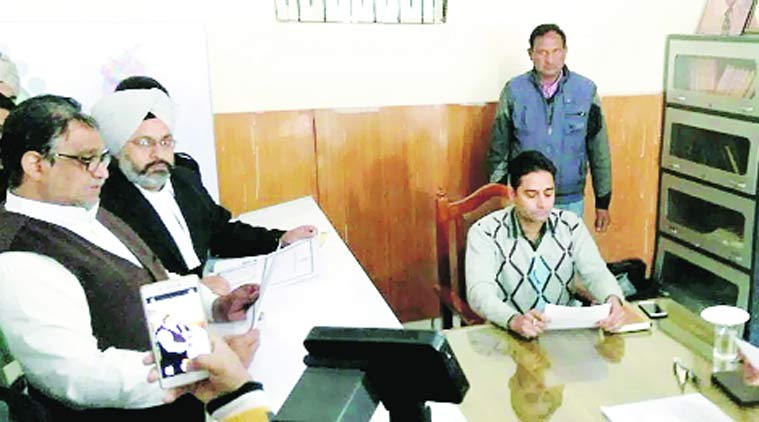 Shiv Lal Doda (left) files his nomination for Abohar while a supporter clicks his photo. (Express Photo)