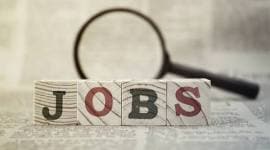 “Jobs” on wooden block and magnifying glass on newspaper background employment, employment rate india, employment in india, jobs in india, india news, india employment