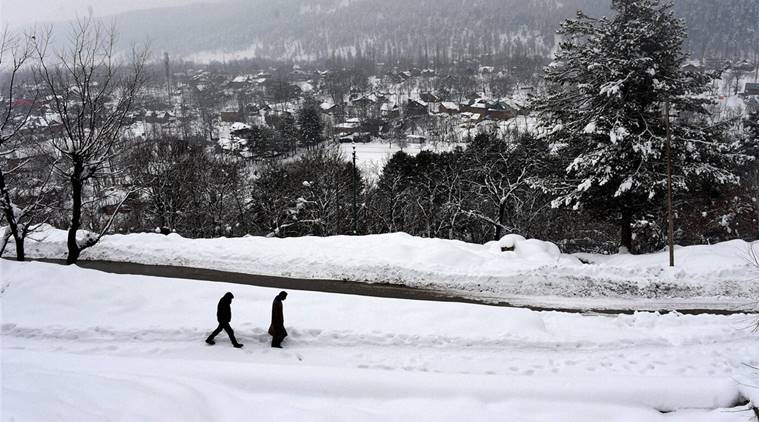 Tangmarg (Kashmir): Two youth walking over snow to reach their destination near Tangmarg along Srinagar-Gulmarg road in north Kashmir on Wednesday. High altitude areas of Kashmir experienced heavy snowfall over the past three days, attracting a large number of tourists. PTI Photo by S Irfan    (PTI1_18_2017_000197B)