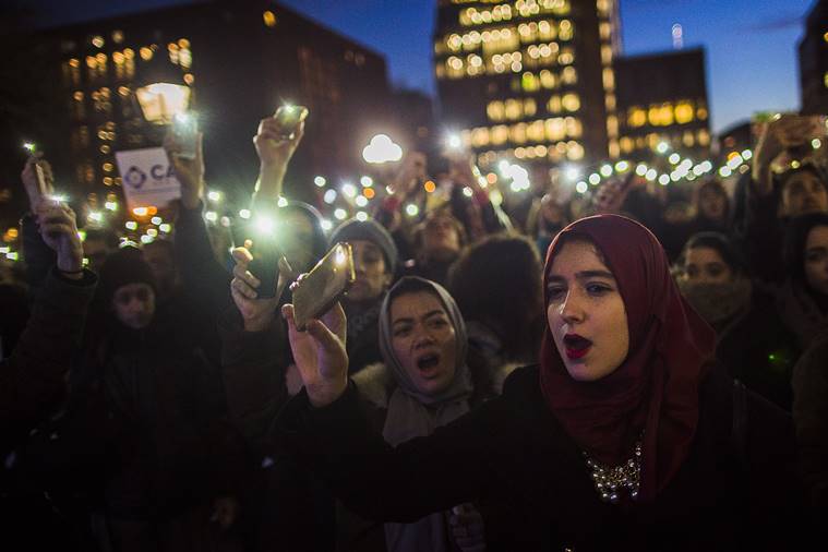 FILE - In this Jan. 25, 2017 file photo, Muslim women shout slogans during a rally against President Donald Trump's order cracking down on immigrants living in the U.S. at Washington Square Park in New York. Many citizens of Muslim-majority countries affected by President Donald Trump’s curbs on travel to the United States say they were hardly surprised the restrictions rank among his first orders of business. (AP Photo/Andres Kudacki)