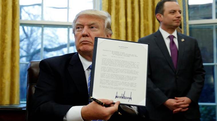 U.S. President Donald Trump holds up the executive order on the reinstatement of the Mexico City Policy after signing in the Oval Office of the White House in Washington January 23, 2017. At his side is White House Chief of Staff Reince Priebus. REUTERS/Kevin Lamarque