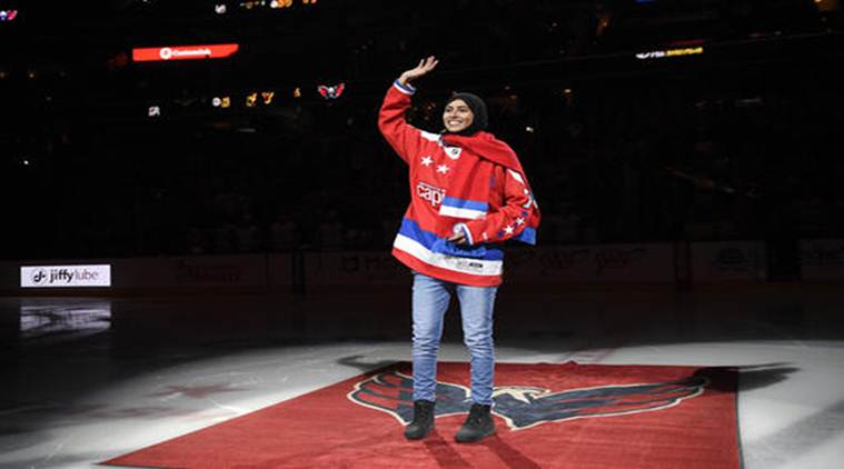 Fatima Al Ali, of the United Arab Emirates, waves to the crowd before she took part in a ceremonial puck drop before an NHL hockey game between the Washington Capitals and the Detroit Red Wings in Washington. (Source:AP)