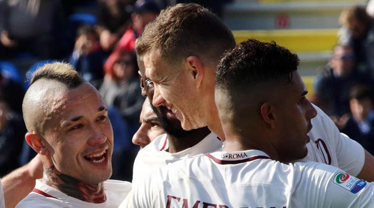 Roma's Edin Dzeko, center, celebrates with his teammates Emerson, right, and Radja Nainggolan after scoring against Crotone during an Italian Serie A soccer match in Crotone, Italy, Sunday, Feb. 12, 2017. Roma won 2-0. (Albano Angilletta/ANSA via AP)