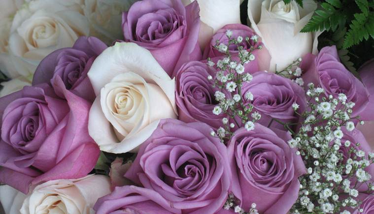 Purple and white roses with baby's breath makeup this beautiful bridal bouquet.