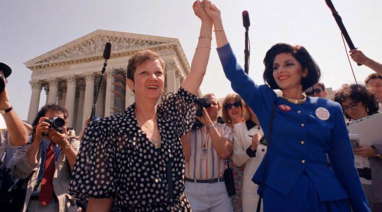 FILE - In this April 26, 1989 file photo, Norma McCorvey, Jane Roe in the 1973 court case, left, and her attorney Gloria Allred hold hands as they leave the Supreme Court building in Washington after sitting in while the court listened to arguments in a Missouri abortion case.   McCorvey died at an assisted living center in Katy, Texas on Saturday, Feb. 18, 2017, said journalist Joshua Prager, who is working on a book about McCorvey and was with her and her family when she died. He said she died of heart failure.(AP Photo/J. Scott Applewhite, File)