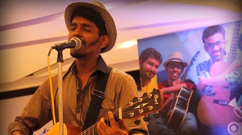 playing music for cancer, Music for cancer, Singers in Mumbai locals, Person playing guitar, playing music in mumbai locals, money for cancer patients, donations for cancer patients, indian express, indian express news.