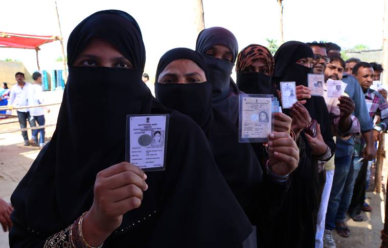 Burqa clad Muslim women show their voter ID card while lined up outside a polling station to cast their vote for BMC elections at Dharavi on Tuesday. Express photo by Prashant Nadkar