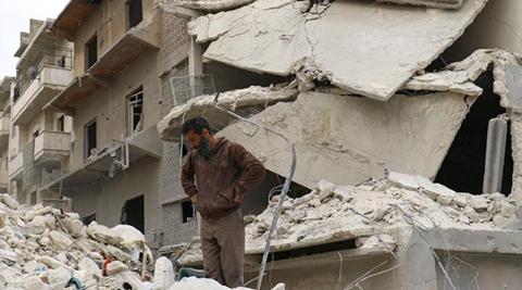 A man stands amid damages at a site hit at dawn by an airstrike in the rebel-controlled town of Ariha in Idlib province, Syria, February 27, 2017. REUTERS/Ammar Abdullah