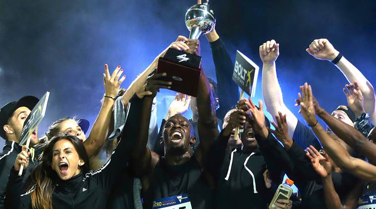Jamaica's Olympic champion Usain Bolt holds the trophy aloft as he celebrates with team mates during the final night of the Nitro Athletics series at the Lakeside Stadium in Melbourne