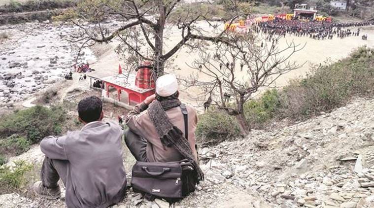 Two men watching a rally deep down in a valley in Pauri. (Source: Express photo by Ashutosh Bhardwaj)