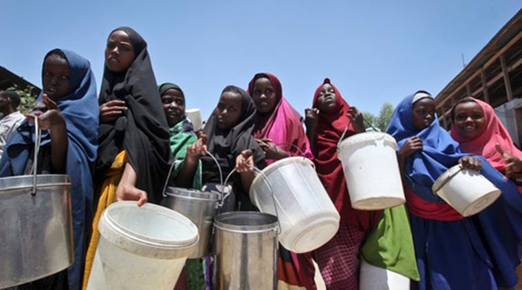 FILE - In this Saturday, Feb. 25, 2017 file photo, displaced Somali girls who fled the drought in southern Somalia stand in a queue to receive food handouts at a feeding center in a camp in Mogadishu, Somalia. Somalia's prime minister said Saturday, March 4, 2017 that 110 people have died from hunger in the past 48 hours in a single region as a severe drought threatens millions of people. (AP Photo/Farah Abdi Warsameh, File)