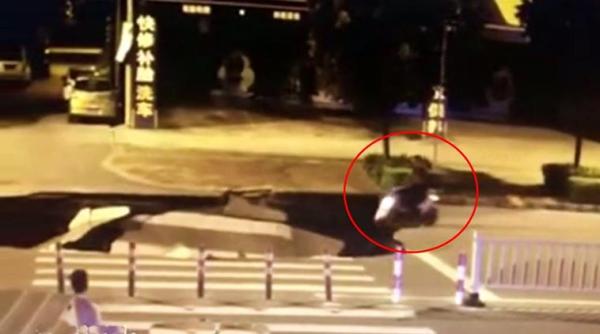 man busy on phone, scooter falls into pit, man on phone drives into sinkhole, man goes into sinkhole video, trending video, indian express, indian express news