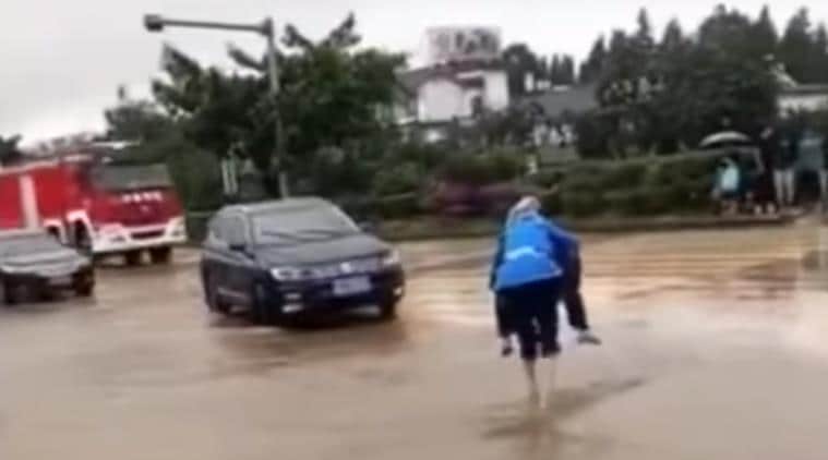 elderly man, old man, man carries wife on back, man carries wife, flooded streets, man carries wife china, china videos, love videos, indian express, indian express news