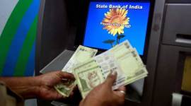 File photo of a man counting money after withdrawing it from a State Bank of India ATM in Mumbai no alt set