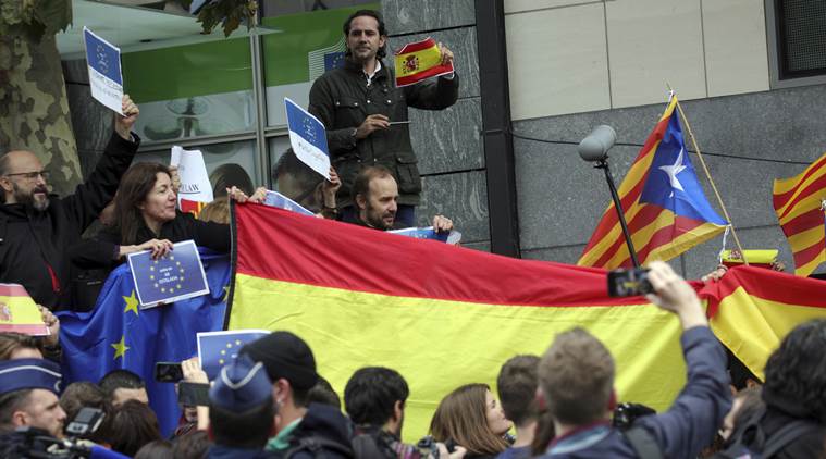 People hold Spanish and Catalonia indolence flags after a speech by sacked Catalonian President Carles Puigdemont in Brussels, Tuesday, Oct. 31, 2017. Ousted Catalan President Carles Puigdemont is calling for avoiding violence and says dialogue is a priority during his first address on Belgian soil. Puigdemont on Tuesday recapped the issues which led him to leave for Belgium the previous day, but did not immediately say in his statement what he would do in Brussels or whether he would seek asylum. (AP Photo/Olivier Matthys)