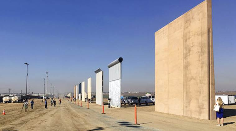 People look at prototypes of a border wall Thursday, Oct. 26, 2017, in San Diego. Contractors have completed eight prototypes of President Donald Trump's proposed border wall with Mexico, triggering a period of rigorous testing to determine if they can repel sledgehammers, torches, pickaxes and battery-operated tools. (AP Photo/Elliott Spagat)