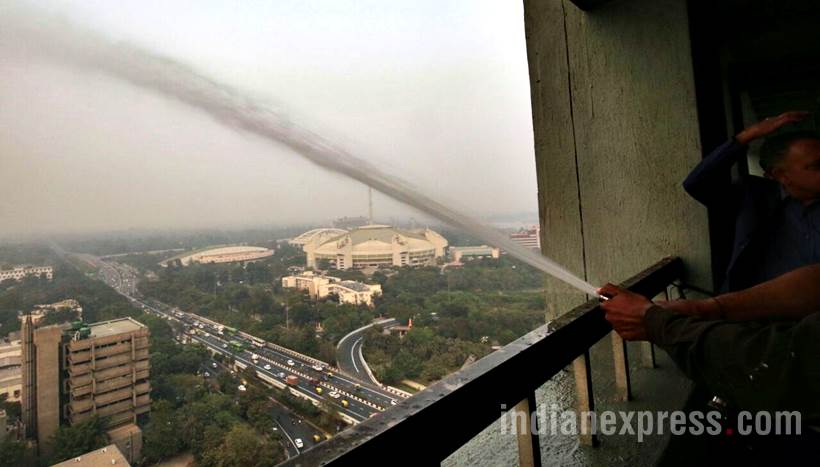 delhi pollution photos, ito water spray photos, water sprayed from building at ito pics, ito water sprinkled pictures, indian express