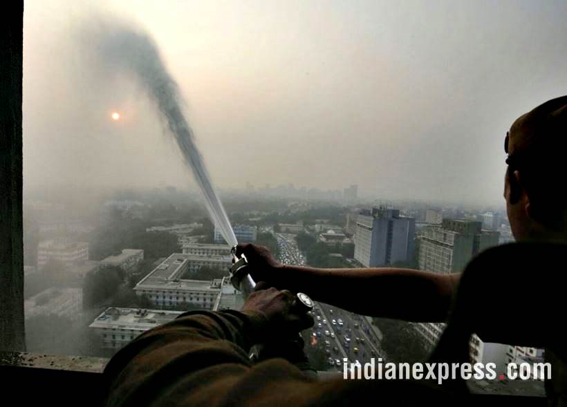 delhi pollution photos, ito water spray photos, water sprayed from building at ito pics, ito water sprinkled pictures, indian express