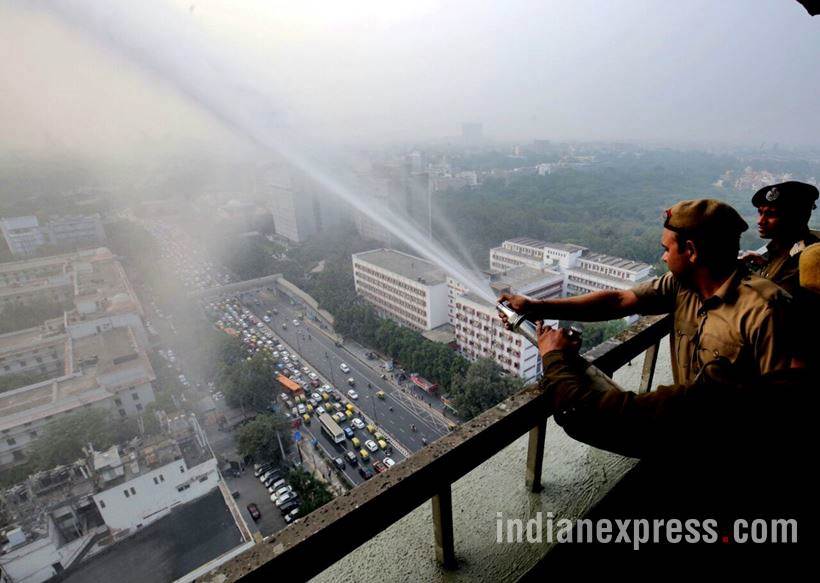 delhi pollution photos, ito water spray photos, water sprayed from building at ito pics, ito water sprinkled pictures, indian express