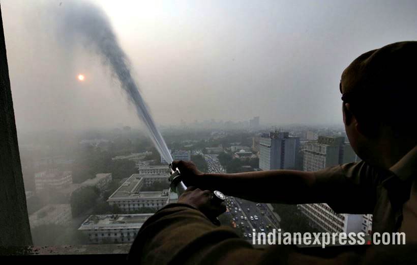 delhi pollution photos, ito water spray photos, water sprayed from building at ito pics, ito water sprinkled pictures, indian express