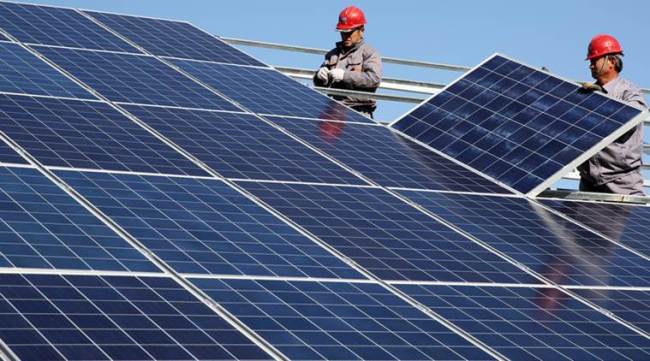 Workers install solar panels at a residential home in a village in Dongying, Shandong province, China November 22, 2017. Picture taken November 22, 2017. REUTERS/Stringer ATTENTION EDITORS - THIS IMAGE WAS PROVIDED BY A THIRD PARTY. CHINA OUT.