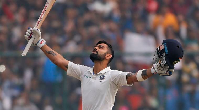 Virat Kohli raises his arms following sixth double century.