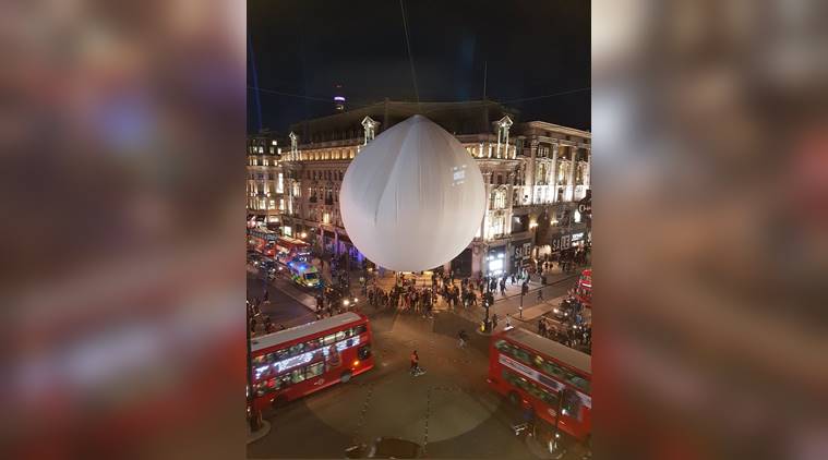 Giant inflatable googly eyes seen on a tree across central London