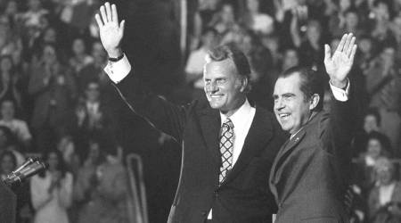 FILE - In this Oct. 16, 1971 file photo, Evangelist Billy Graham and President Nixon wave to a crowd of 12,500 at ceremonies honoring Graham at Charlotte, N.C.   Graham, who transformed American religious life through his preaching and activism, becoming a counselor to presidents and the most widely heard Christian evangelist in history, has died. Spokesman Mark DeMoss says Graham, who long suffered from cancer, pneumonia and other ailments, died at his home in North Carolina on Wednesday, Feb. 21, 2018. He was 99. (AP Photo, File)