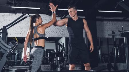 sportive couple giving high five to each other in gym