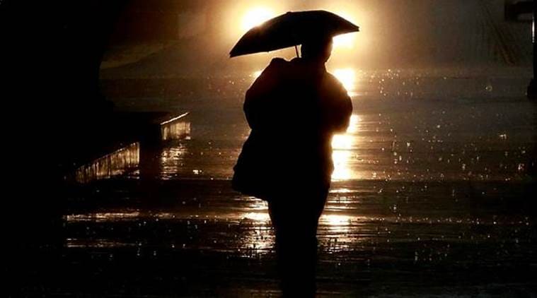 A pedestrian shields himself from the rain as a storm moves through southern California. (AP)