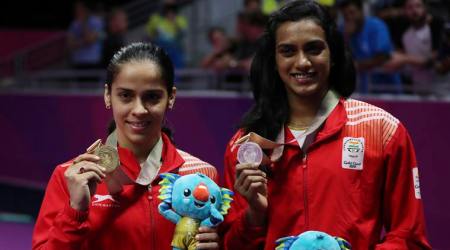 Gold medalists Saina Nehwal, left, and silver medalist Venkata Pusarla, both of India, pose for photographers during the medal ceremony for women's singles badminton at Carrara Sports Hall during the Commonwealth Games on the Gold Coast, Australia, Sunday, April 15, 2018. (AP Photo/Dita Alangkara)