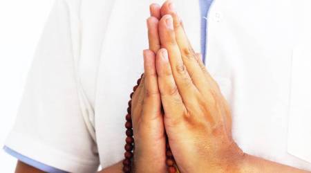 A man who prayer or chant with necklace.