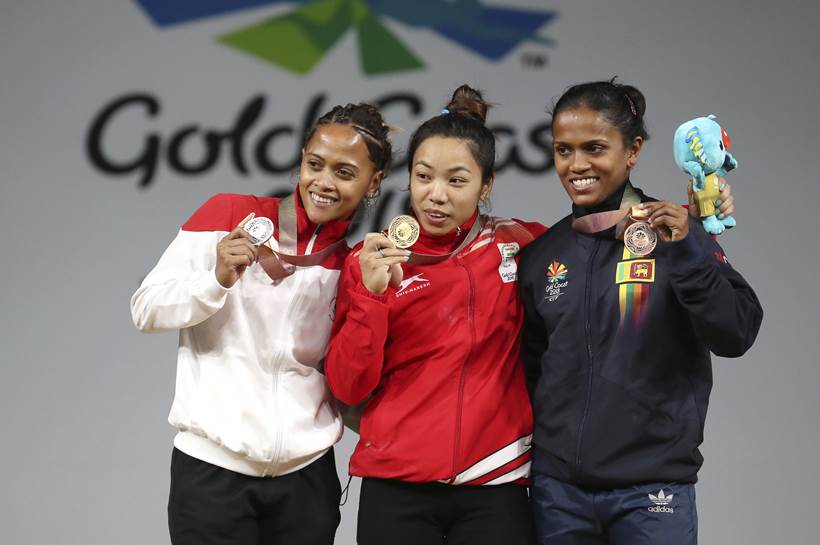 Mirabai Chanu at the podium with medallists