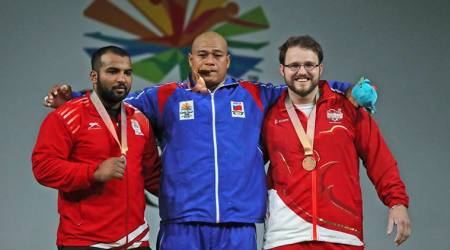 Samoa's Men's 105Kg Weightlifting Gold medalist Sanele Mao, center, stands with India Silver medalist Pradeep Singh, and England Bronze medalist Owen Boxall during medal ceremony at the Commonwealth Games, in Gold Coast, Australia, Monday, April 9, 2018. (AP Photo/Manish Swarup)