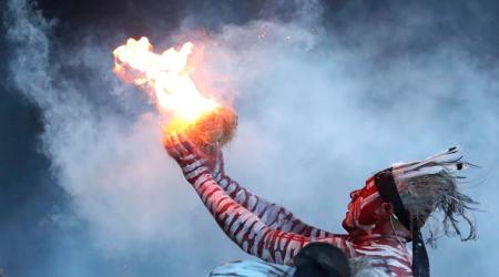 Flames burst from tinder held by an Aboriginal man during a traditional smoking ceremony during the opening ceremony for the 2018 Commonwealth Games at Carrara Stadium on the Gold Coast, Wednesday, April 4, 2018. (AP Photo/Dita Alangkara)