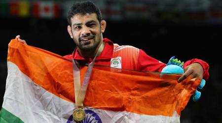 India's Sushil Kumar poses with the national flag after wining in men's FS 74Kg wrestling against South Africa's Johannes Botha at the Commonwealth Games on Gold Coast, Australia, Thursday, April 12, 2018. (AP Photo/Manish Swarup)